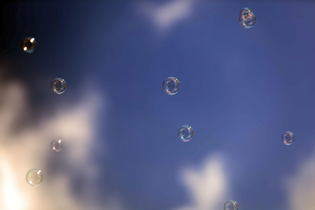 Of soap bubbles flying in a blue sky blown by windの写真素材