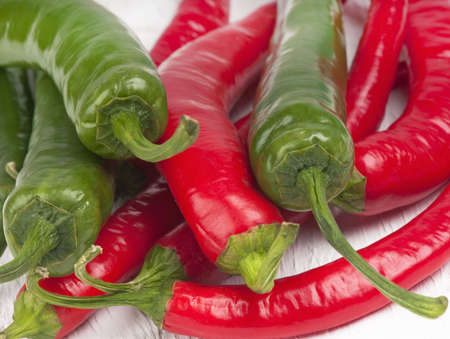 macro of a pile of red and green hot chilli peppers.
