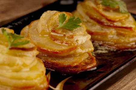 Three potato stacks made from sliced potato baked in the oven until brown and crisp with plenty of butterの写真素材