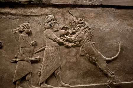 LONDON - JANUARY 9 2014 - Assyrian Lion Hunt relief from the British Museum which depicts the last great Assyrian king, Ashurbanipal 668-631 BC, killing a lion with his sword.  It was  created for his palace at Nineveh in northern Iraq.のeditorial素材