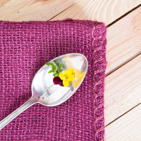 antik silver spoon on a purple fabricの写真素材