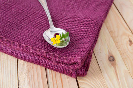 antik silver spoon on a purple fabricの写真素材