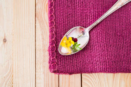 antik silver spoon on a purple fabricの写真素材