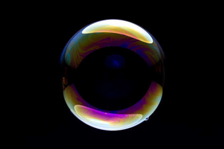 single colorful soap bubble against black backgroundの写真素材