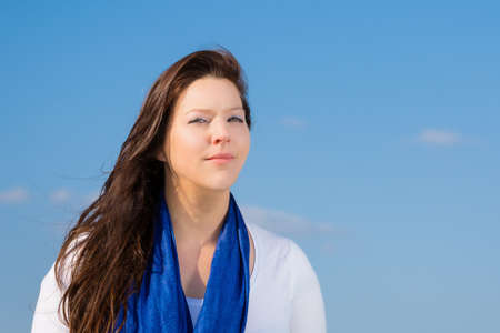 woman with a blue scarf against blue skyの写真素材