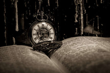 bible with a steampunkt clock as still life for halloweenの写真素材