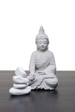 grey stone buddha with stones against white backgroundの写真素材