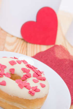 sweet tasty donut with white glaze red sugar  hearts and red heart for decorationの写真素材