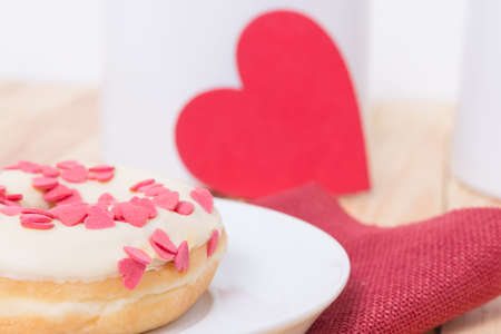 sweet tasty donut with white glaze red sugar  hearts and red heart for decorationの写真素材