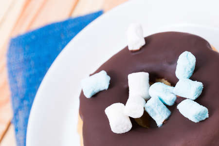 sweet delicious donut with chocolate icing and marshmallowsの写真素材