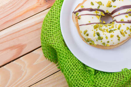 sweet delicious donut with white icing and pistachiosの写真素材