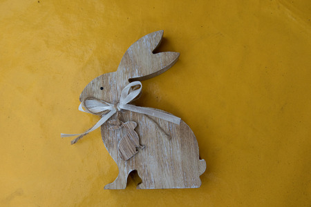 one easter bunny on a yellow tablecloth with copy space and photographed in the garden during easter on a sunny spring dayの写真素材