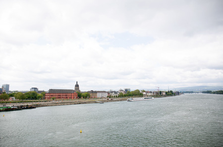 Distant view on a riverbank at the rhine river from mainz germany photographed on a cloudy day