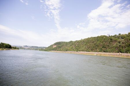 View along the rhine river under blue sky in koblenz germany