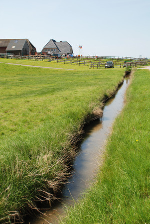 A ditch on the Hallig Hooge, Germany. The Halligen (singular Hallig) are ten small German islands without protective dikes in the North Frisian Islands on Schleswig-Holstein's Wadden Sea-North Sea coast in the district of Nordfrieslandの写真素材