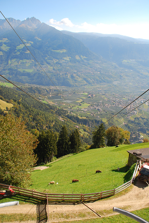 Panorama view on valleys (Meran) and mountains in the italian alps standing at the cableway station Hochmuth (Meran, South Tyrol, Italy)の写真素材