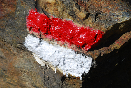 Red and white track mark on a stone. Forest route, hiking pathway trail sign. Ultental Valley, South Tyrol, Italyの写真素材