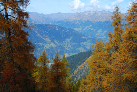 Hiking in the 'Hirzer' area with impressive autumn scenery, Sarntal Alps, South Tyrol, Italy. In the distance the mountains of the Texel group and the Passeier Valleyの写真素材