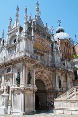 Venice, Italy: The Arco Foscari is in the courtyard of the Doge's Palace (Ital.: Palazzo Ducale), San Marco basilica behind itの写真素材