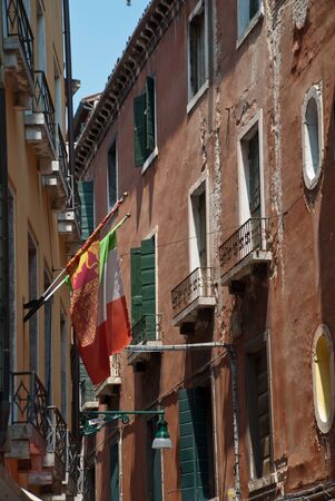 Venice, Italy: traditional house facade with italian flag, district San Marcoの写真素材