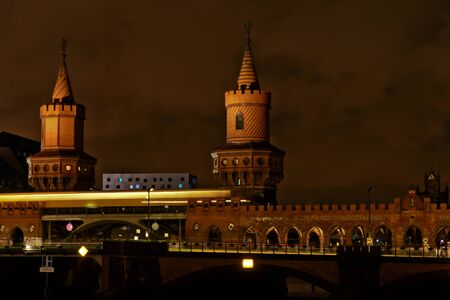 Oberbaumbruecke bridge at Spree river connecting east and west parts of Berlin, at night, with train passing by in long exposureのeditorial素材