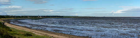 Wadden Sea at low tide on Amrum Island, North Sea, North Frisian Island, Schleswig-Holstein, Germany. In the Distance the village Nebel, panorama pictureの写真素材