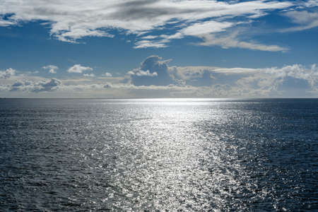 Cloudy blue sky leaving for horizon above a blue surface of the North Seaの写真素材