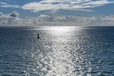 Cloudy blue sky leaving for horizon above a blue surface of the North Seaの写真素材