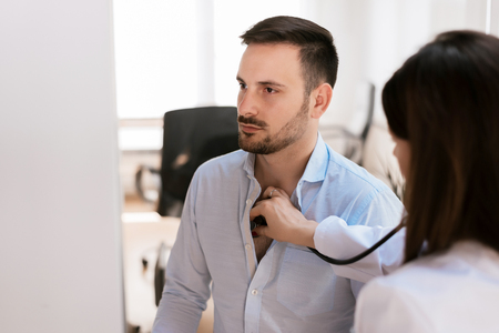 Doctor listening heartbeat of patient with stethoscope.の写真素材