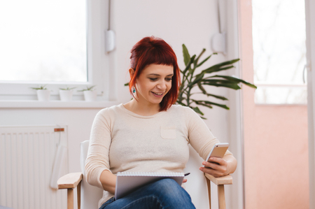 Woman using mobile at homeの写真素材