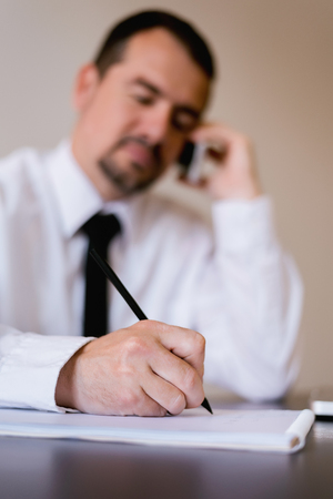 Close up of elder businessman signing contract or documents at his office. Business concept.の写真素材