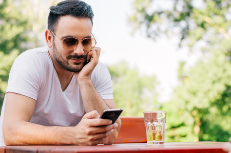 Young man texting in the cafeの写真素材