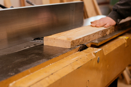 Carpenter working with industrial tool in wood factory, circular blade with a wood board.の写真素材