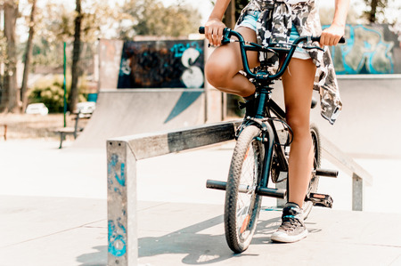 Legs of pretty girl sitting on bicycle in urban environmentの写真素材