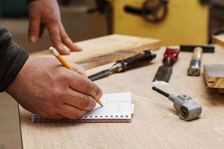 Carpenter calculates dimensions. Carpentry workshop.の写真素材