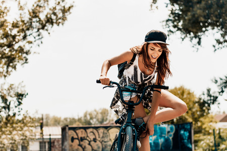 Attractive young woman standing next to her bikeの写真素材