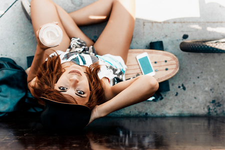 Beautiful and fashion young woman posing with a skateboardの写真素材