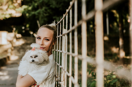 Portrait of pretty young woman enjoying time with a maltese dog