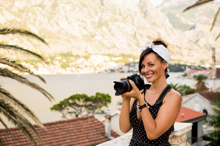 Happy woman on vacation photographing with a dslr camera