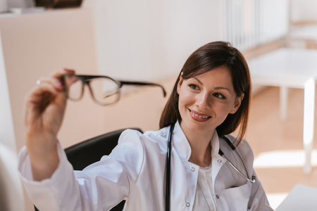 Portrait of female doctor holding glassesの写真素材