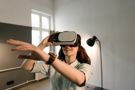 Happy woman gets experience of using VR-glasses, virtual reality headsetの写真素材