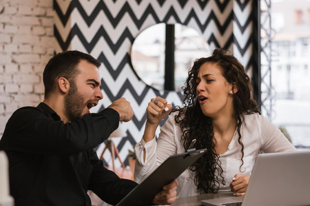 Business partners giving fist bump, successful teamworkの写真素材