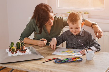Mother looking how her child son drawing a pictureの写真素材