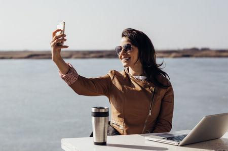 Beautiful woman outside taking selfieの写真素材