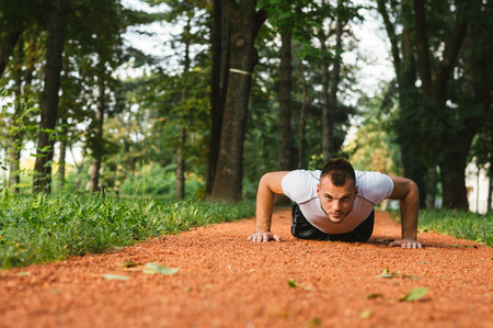 Cross-training during sunset. Young man doing push ups.の写真素材