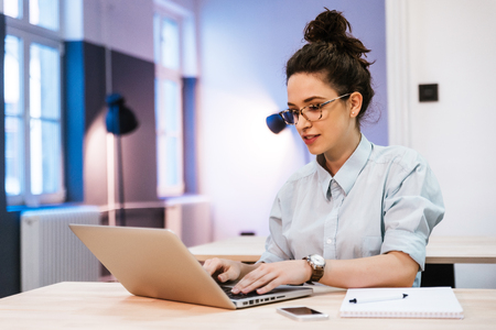 Tilt up of smiling woman being busy working in the middle of the dayの写真素材