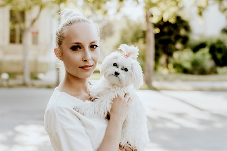 Portrait of young woman with a maltese dogの写真素材