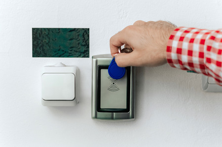 Close up hand using keycard to open door.