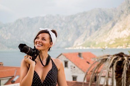 Beautiful stylish woman holding camera outside.の写真素材