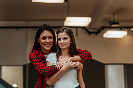 Portrait of two beautiful girls, hugging and smiling. Sisters, together.の写真素材